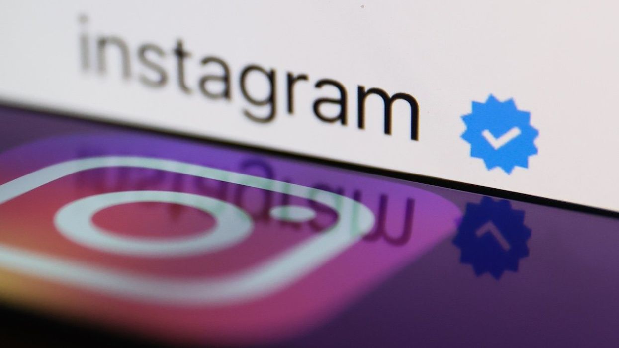 A blue verification checkmark on Instagram account on Instagram displayed on a laptop screen and Instagram logo displayed on a phone screen are seen in this illustration photo taken in Poland on February 19, 2023.