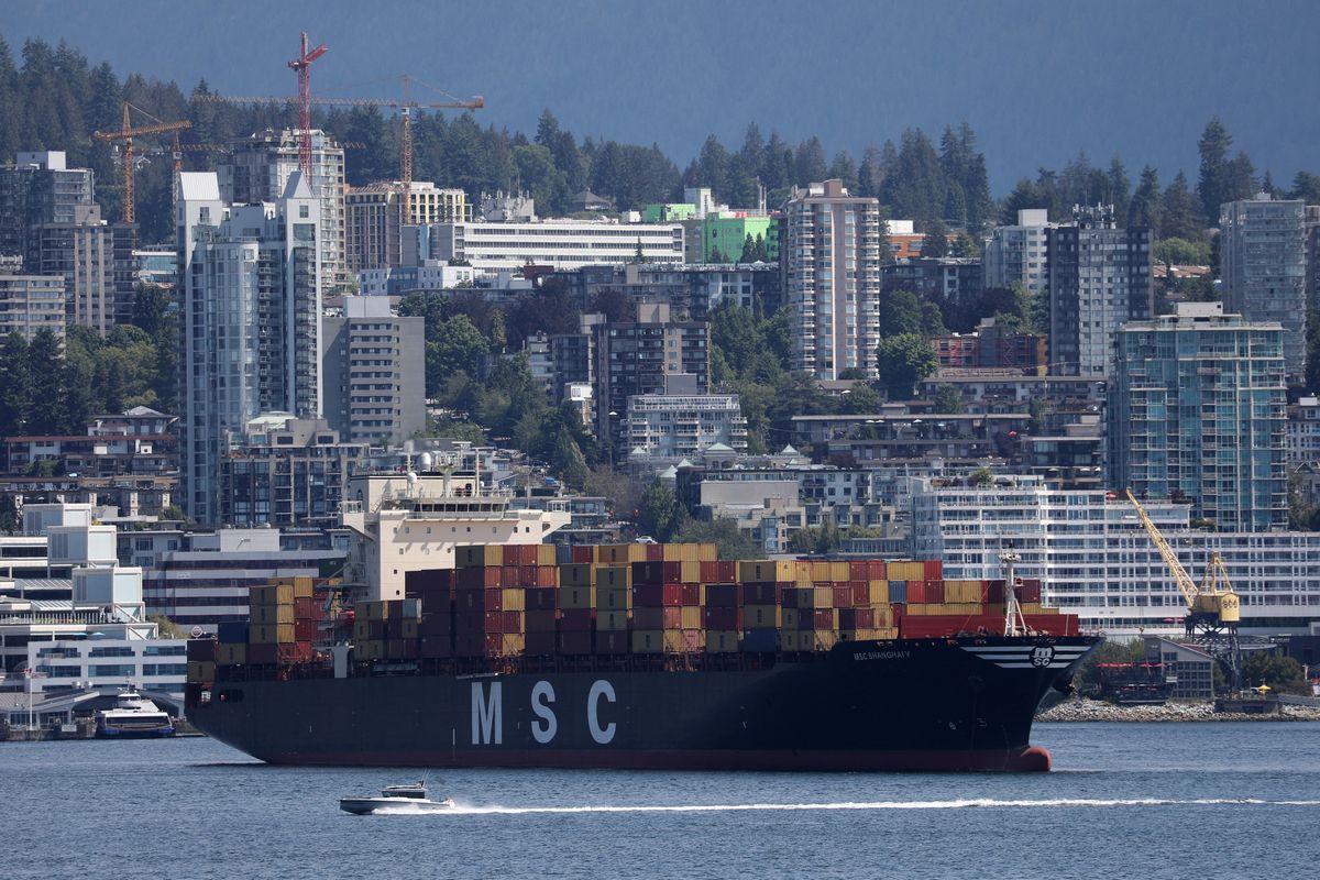 A boat passes a container ship at anchor during a strike by the International Longshore and Warehouse Union Canada at Canada's busiest port of Vancouver, British Columbia.