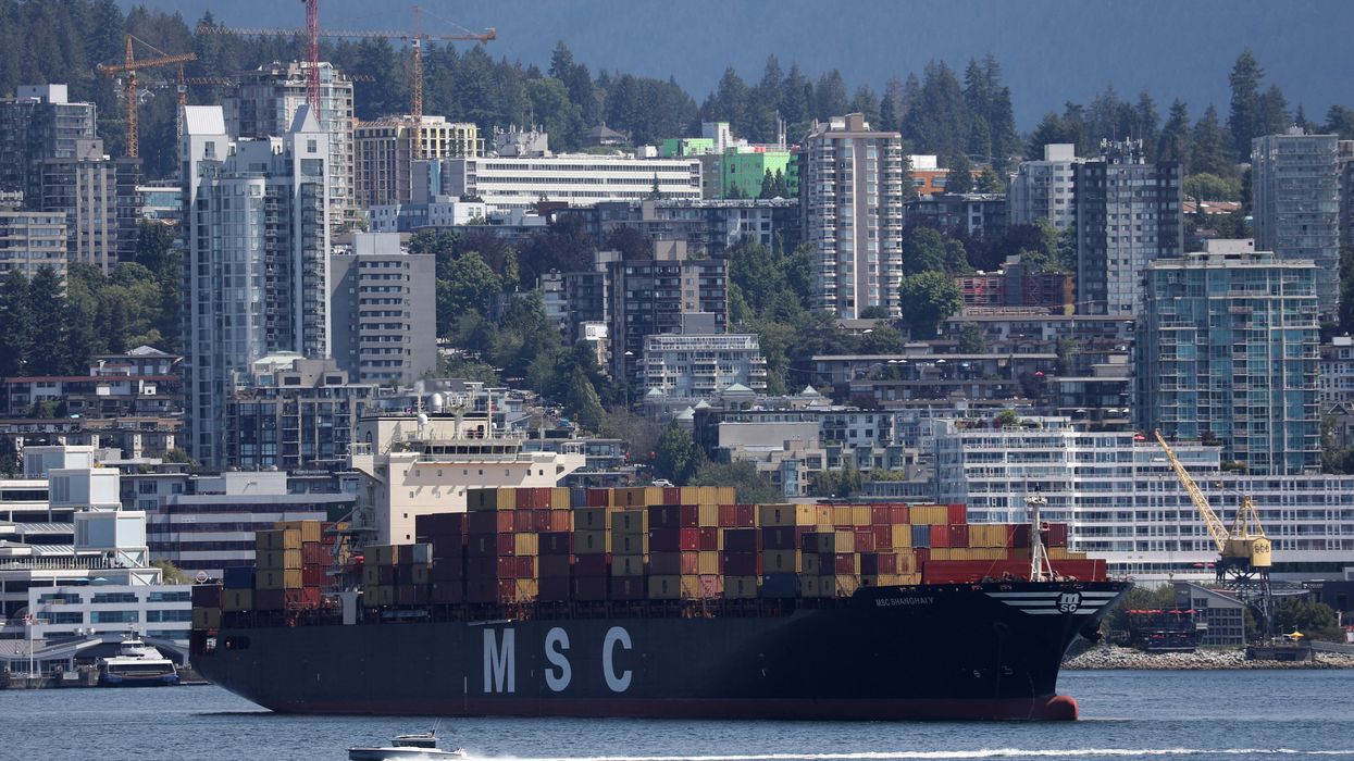 A boat passes a container ship at anchor during a strike by the International Longshore and Warehouse Union Canada at Canada's busiest port of Vancouver, British Columbia.