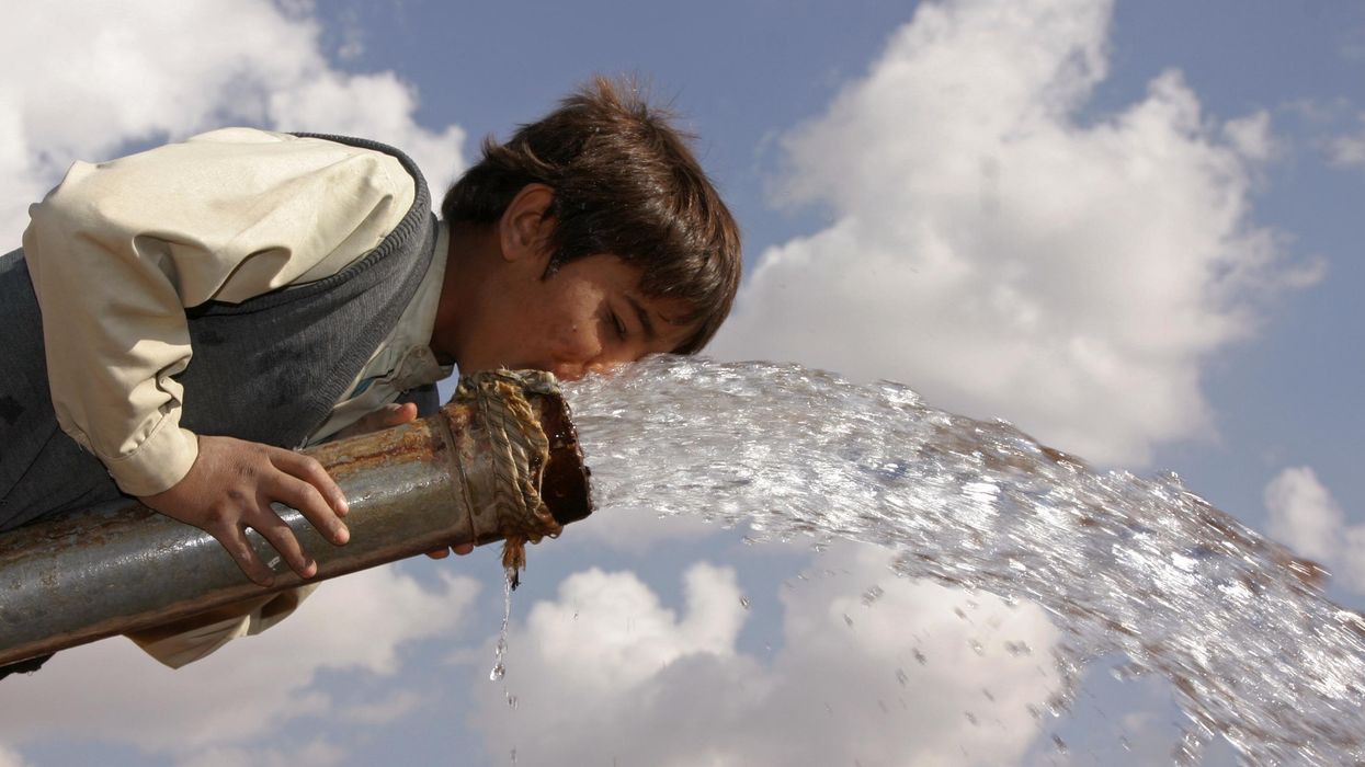 A boy drinks from a water pump in a village outside Sanaa, Yemen.