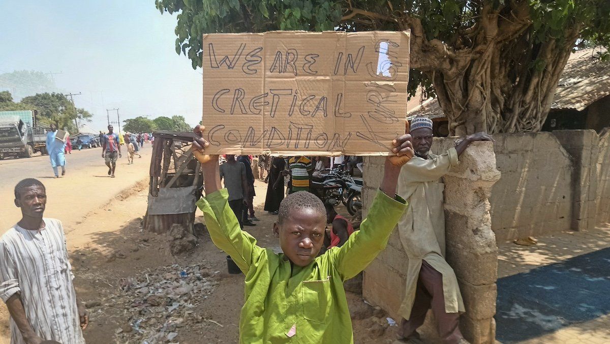 ​A boy holds a sign to protest against, what a teacher, local councilor and parents said, the kidnapping of hundreds school pupils by gunmen after the Friday prayer, in Kaduna, Nigeria March 8, 2024. 