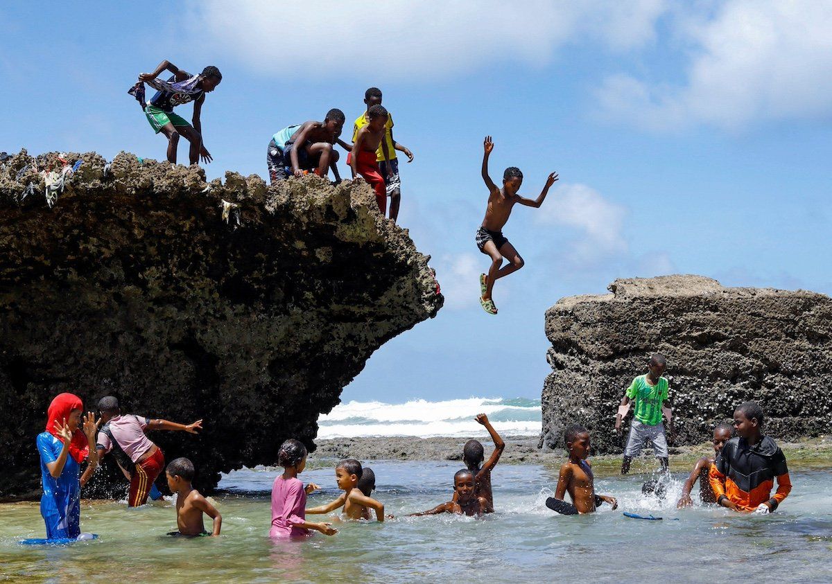 A boy jumps into the Indian Ocean waters to join other revellers in Hamarweyne district of Mogadishu, Somalia May 11, 2023. 