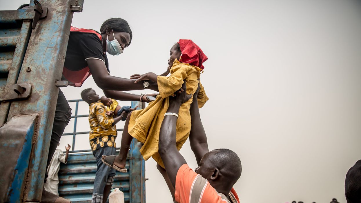 A child is loaded into a truck taking people fleeing Sudan's war from Joda, on the Sudanese border