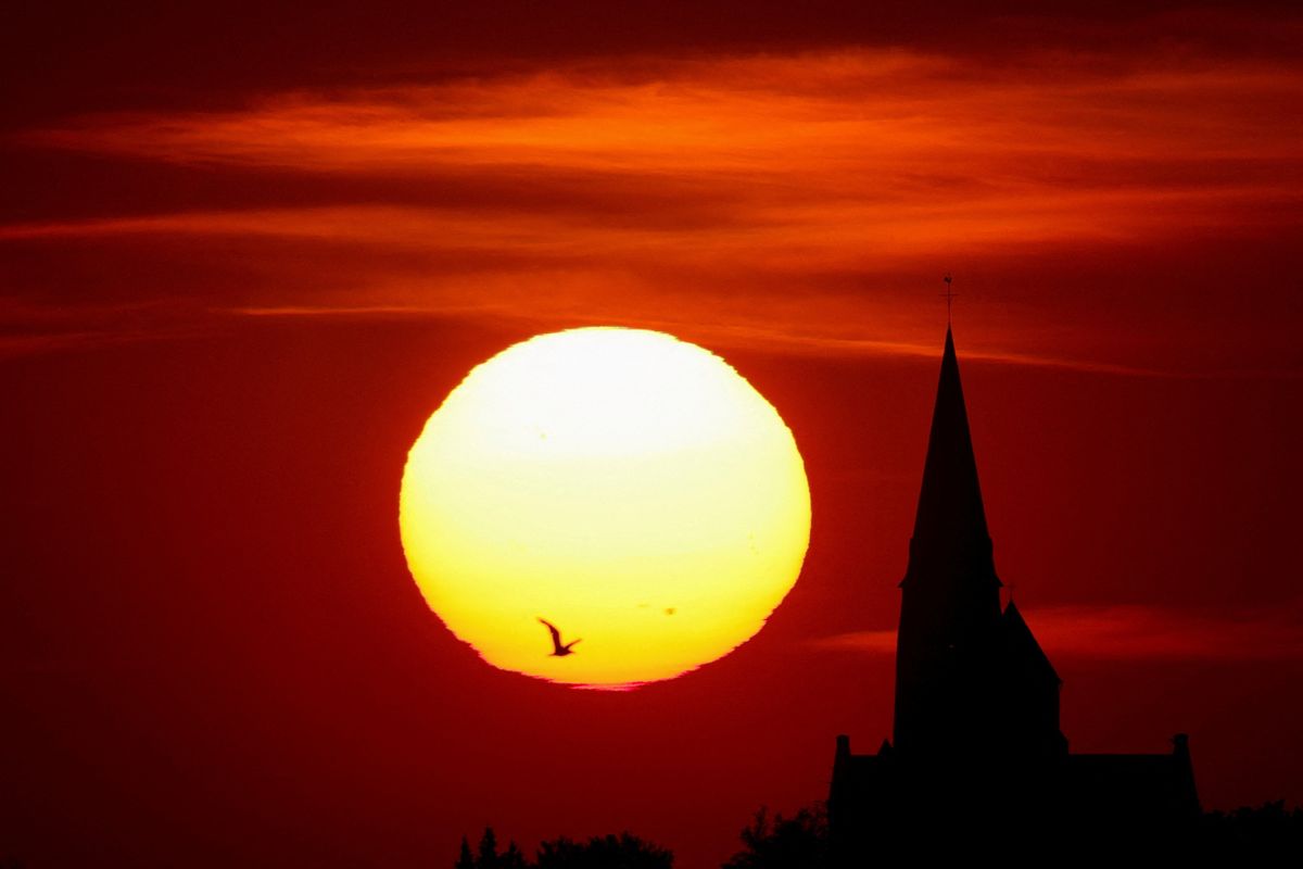 A church is pictured during sunset as a heat wave hits Europe in Oisy-le-Verger, France.
