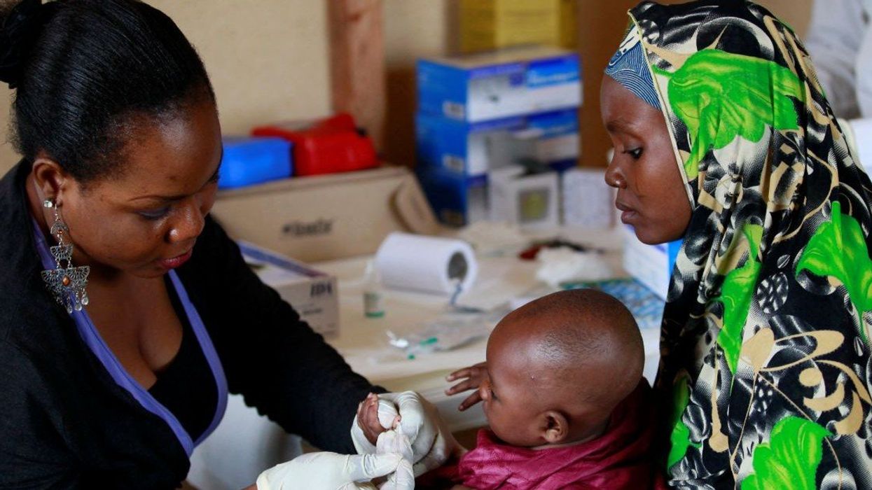 A clinic support staff takes blood sample from a child at a clinic operated by Doctors without Borders in Bagega village in northeastern state of Zamfara August 14, 2013. Picture taken August 14, 2013.