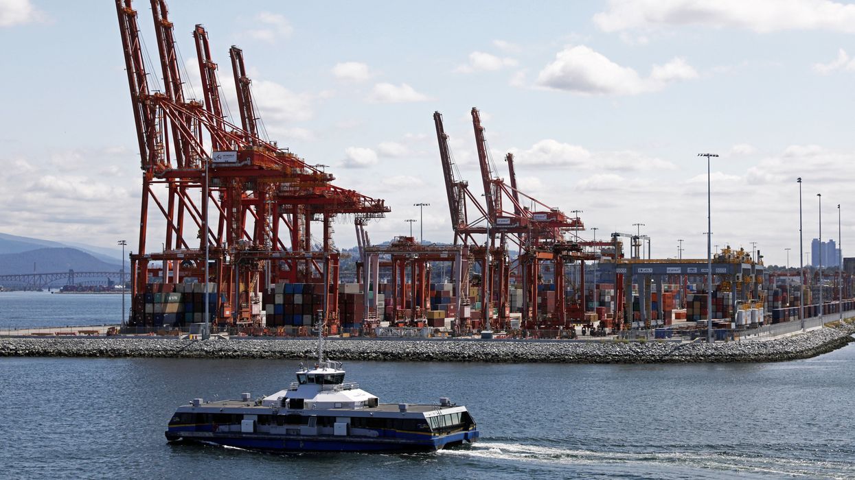 A commuter Seabus passes idle shipping cranes towering over stacked containers during a strike by dock workers at Canada's busiest port of Vancouver, British Columbia.