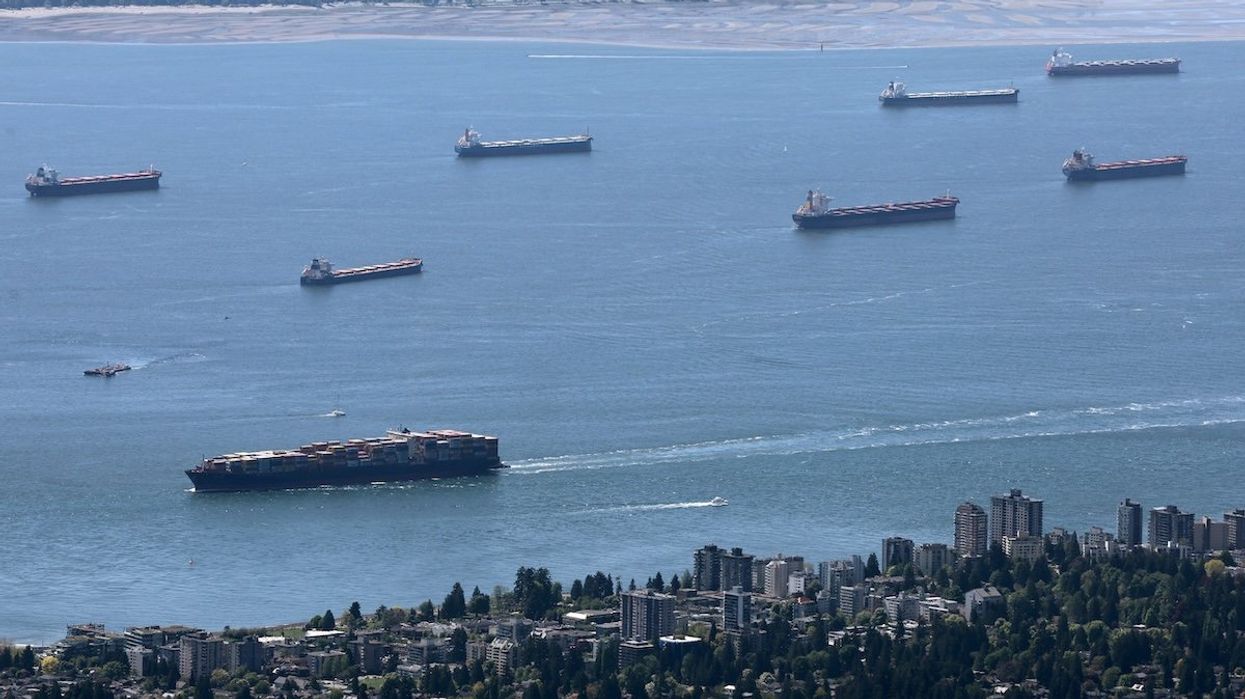 A container ship makes its way into the Port of Vancouver past vessels at anchor in English Bay, as seen from Grouse Mountain in North Vancouver, British Columbia, on May 10, 2024.