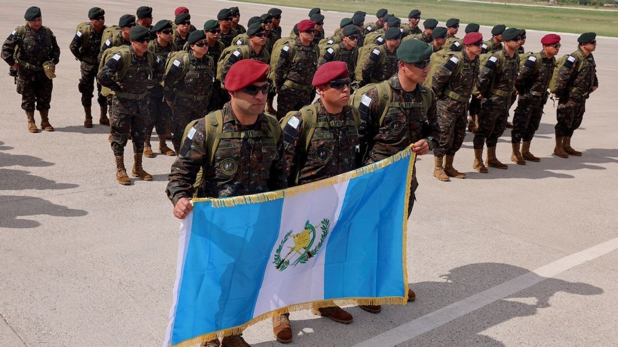 A contingent of security forces from Guatemala holds a Guatemala flag as they arrive in Haiti for a security mission, at Toussaint Louverture International Airport in Port-Au-Prince Haiti January 4, 2025.