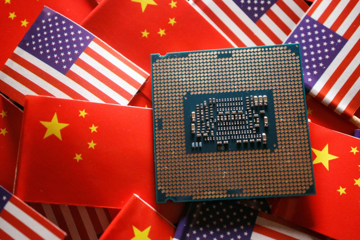 A CPU semiconductor chip is displayed among flags of China and the US.