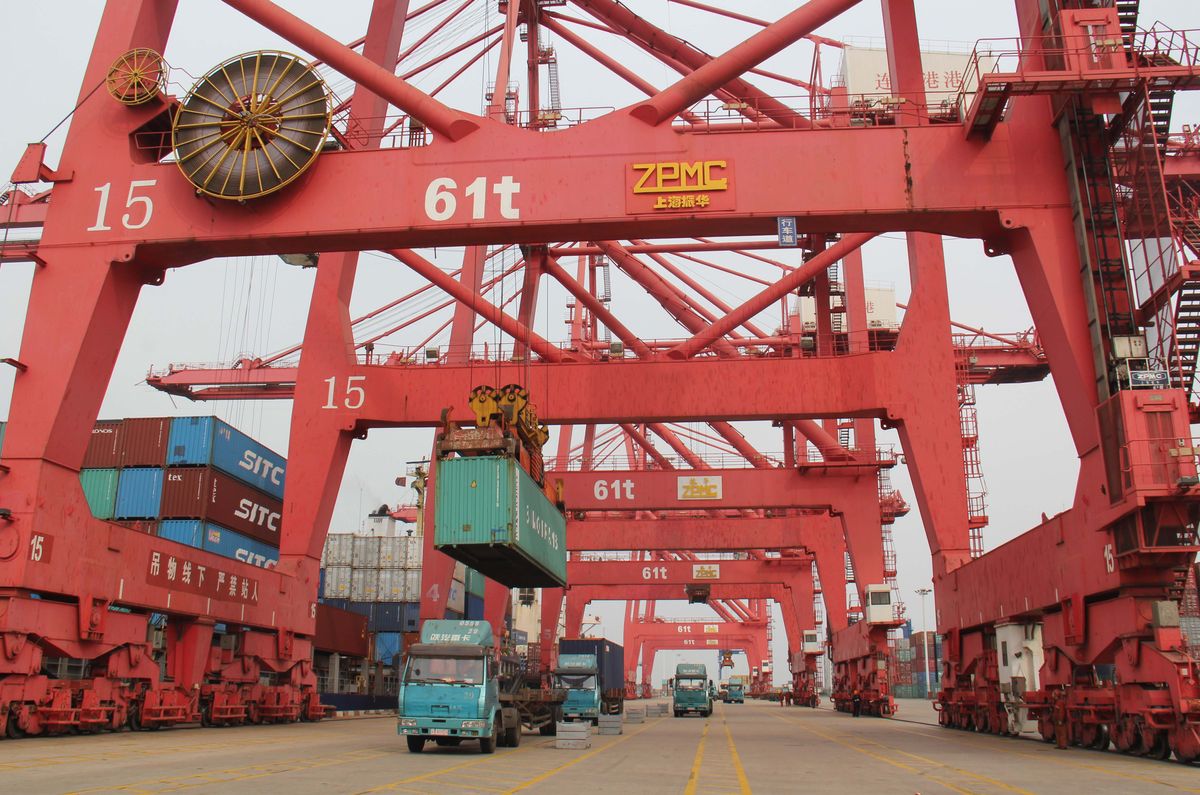 A crane unloads a container on a truck at the Port of Lianyungang in Lianyungang city, east China's Jiangsu province