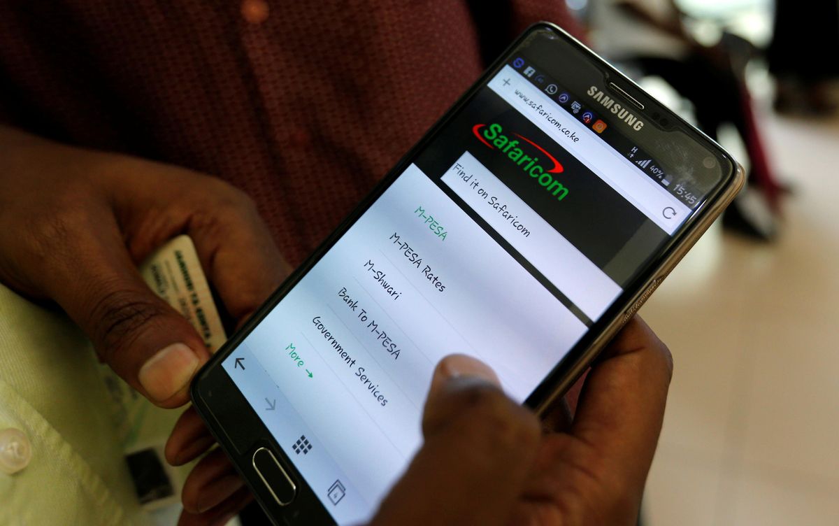 A customer sets-up M-Pesa money transfer servive inside a store operated by Kenyan's telecom operator Safaricom. 