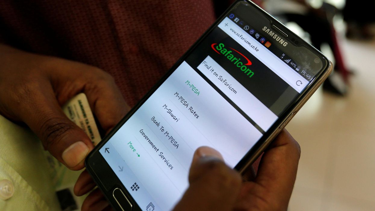 A customer sets-up M-Pesa money transfer servive inside a store operated by Kenyan's telecom operator Safaricom.