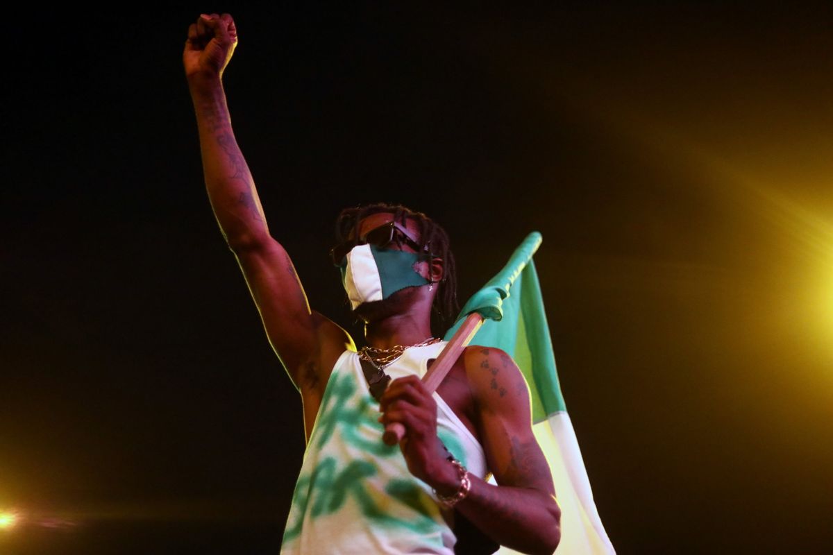 A demonstrator gestures as he holds the Nigerian flag during protest against alleged police brutality in Lagos. Reuters