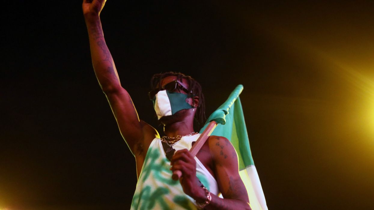 A demonstrator gestures as he holds the Nigerian flag during protest against alleged police brutality in Lagos. Reuters