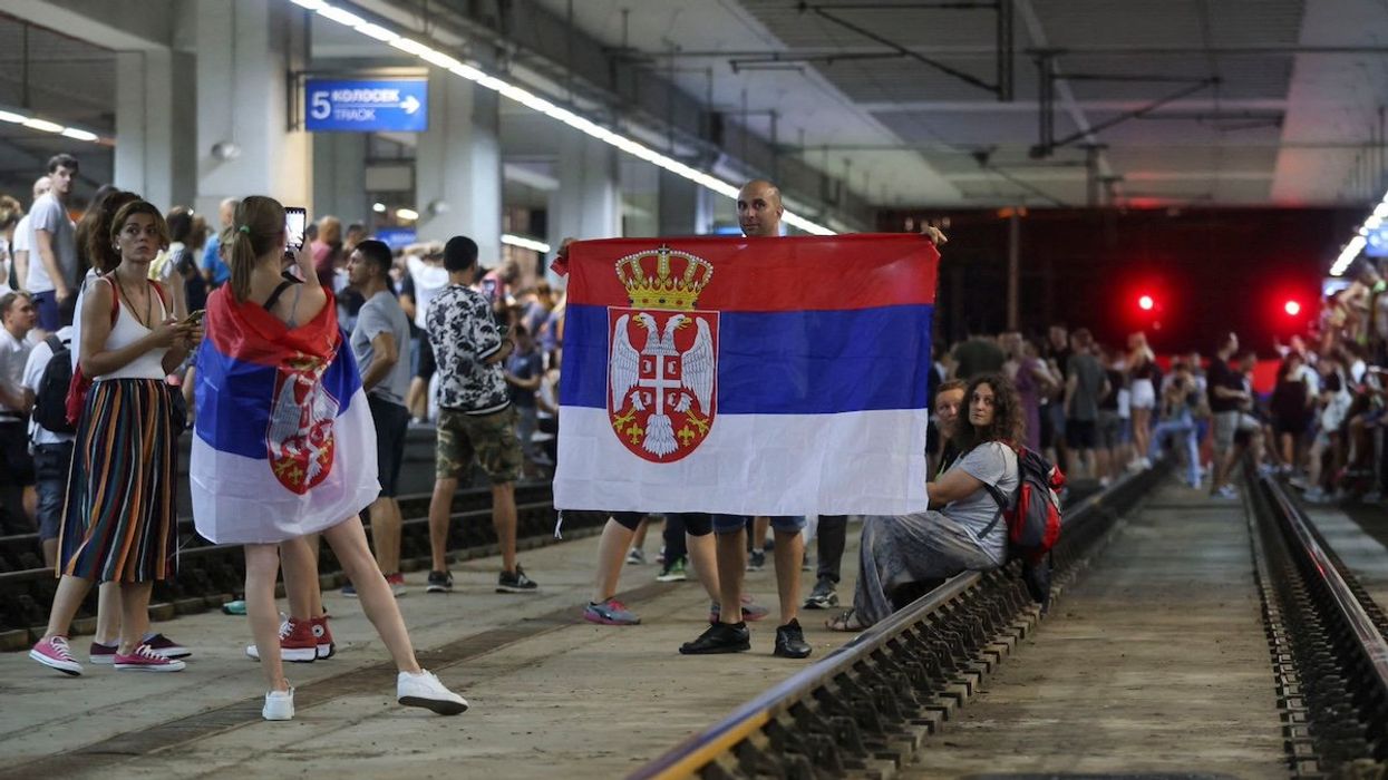 A demonstrator holds a flag as people block the Centre Railway Station during a protest against Rio Tinto's lithium mining project, in Belgrade, Serbia, August 10, 2024.