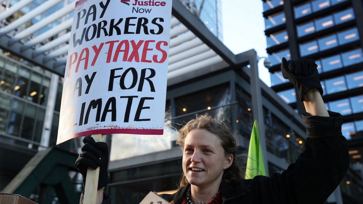 A demonstrator holds a placard during a protest outside the Amazon headquarters during Black Friday in London, Britain, November 24, 2023.