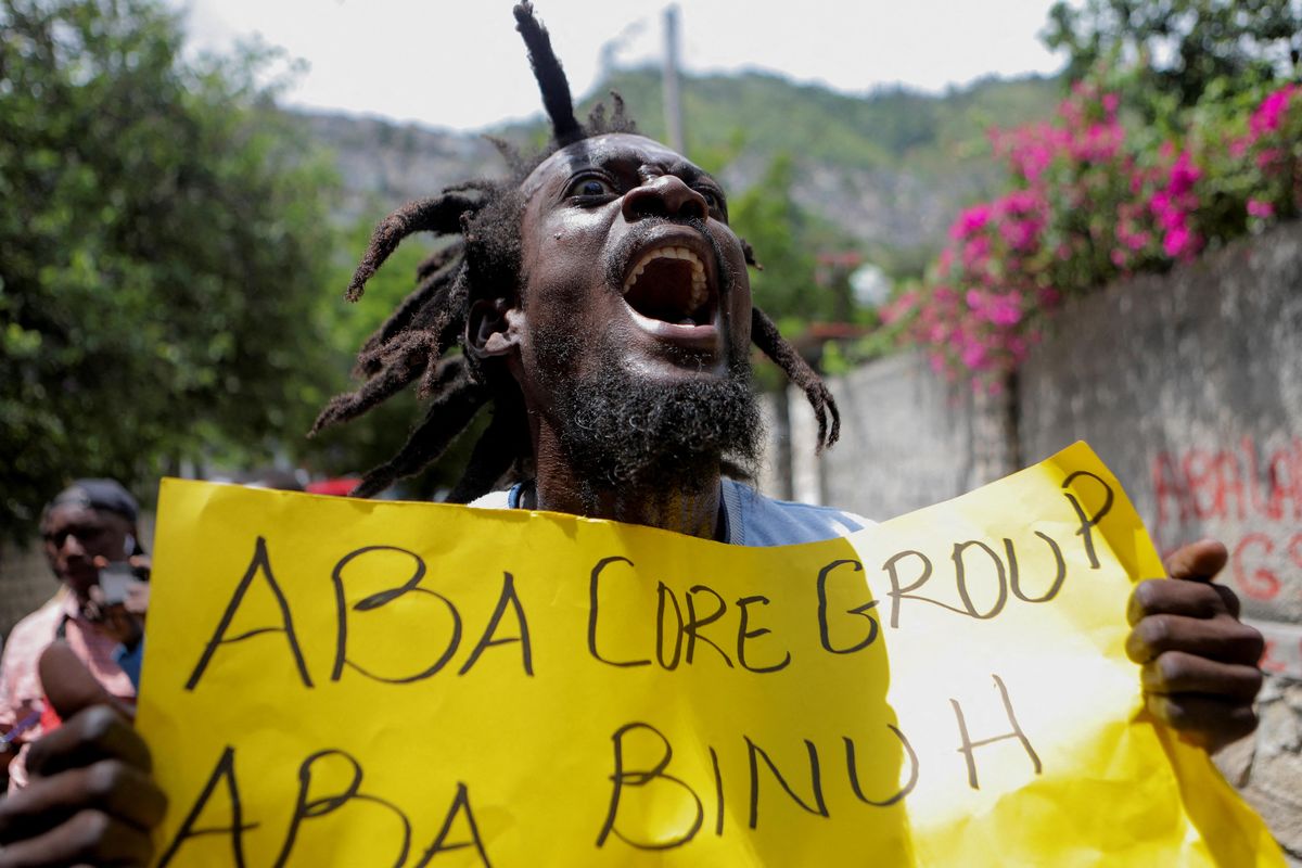 A demonstrator holds a sign reading "No more Core Group (a group of international diplomats), no more BINUH (the United Nations Integrated Office in Haiti)" during a protest against the government in Port-au-Prince.
