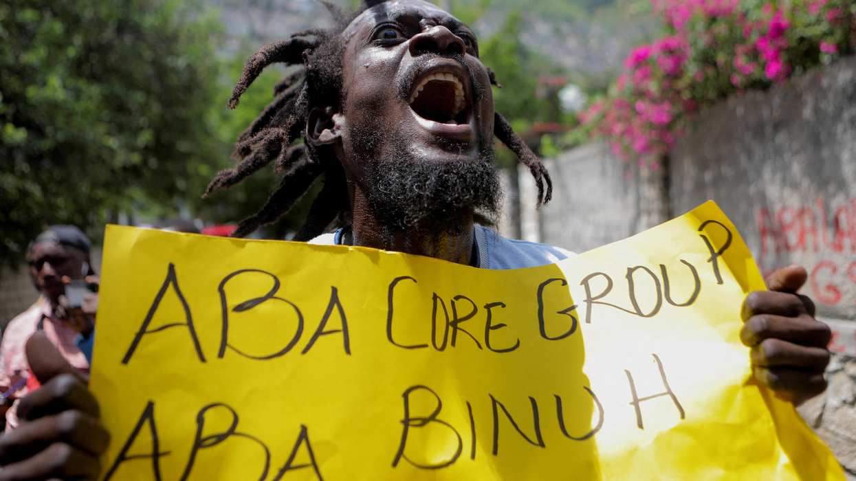 A demonstrator holds a sign reading "No more Core Group (a group of international diplomats), no more BINUH (the United Nations Integrated Office in Haiti)" during a protest against the government in Port-au-Prince.