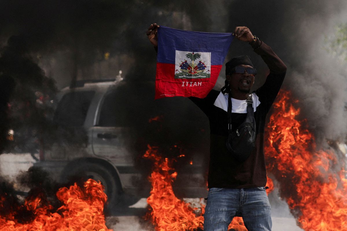 ​A demonstrator holds up a Haitian flag during a protest against Prime Minister Ariel Henry's government and insecurity, in Port-au-Prince, Haiti March 1, 2024. 