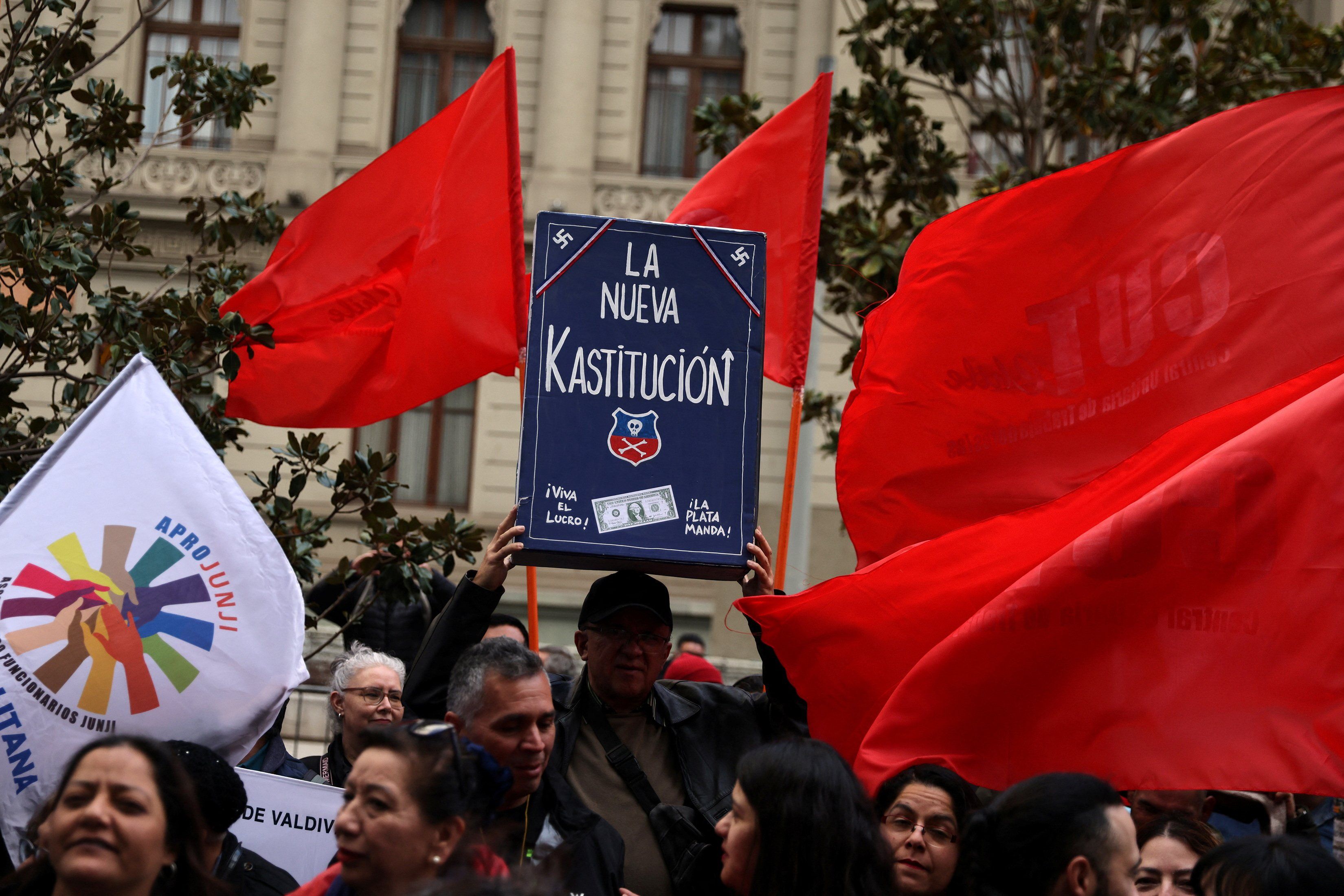 A demonstrator holds up a model depicting a Chilean constitution book that reads 'The new Kastitucion' in a play on the word 'Constitution' and the name of far right-wing politician Jose Antonio Kast, while protesting against ongoing Constitutional process lead by right-wing parties, in Santiago, Chile, October 3, 2023.