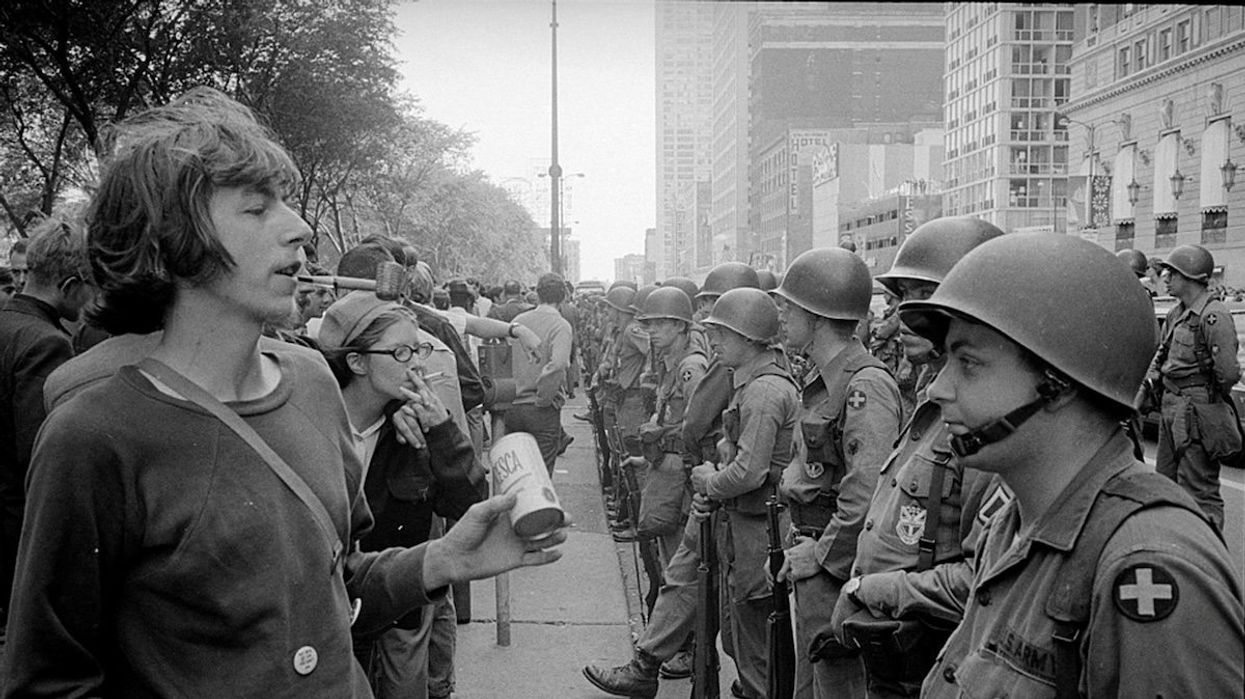 A demonstrator stands in front of a row of National Guard soldiers, across the street from the Hilton Hotel in Grant Park, site of the Democratic National Convention in Chicago, Illinois, on Aug. 26, 1968.