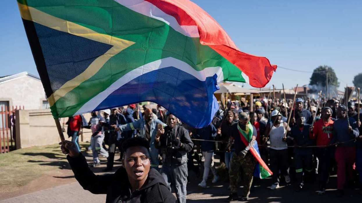 A demonstrator waves South Africa's flag during a protest calling for the deportation of undocumented immigrants
