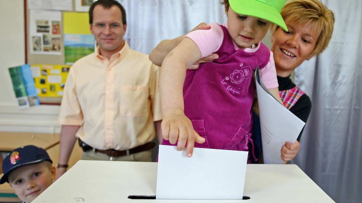 A family votes during the second round of Hungary's general election in Budapest, April 23, 2006. Hungarians went to the polls on Sunday with the Socialist-led government of Prime Minister Ferenc Gyurcsany looking set to make history by becoming the first to retain power since the return of democracy in 1990.