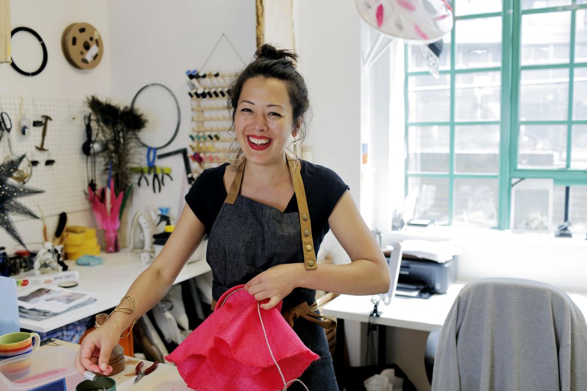 A female entrepreneur shown smiling in her shop. 