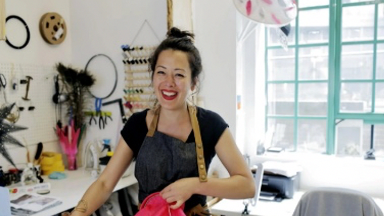 A female entrepreneur shown smiling in her shop.