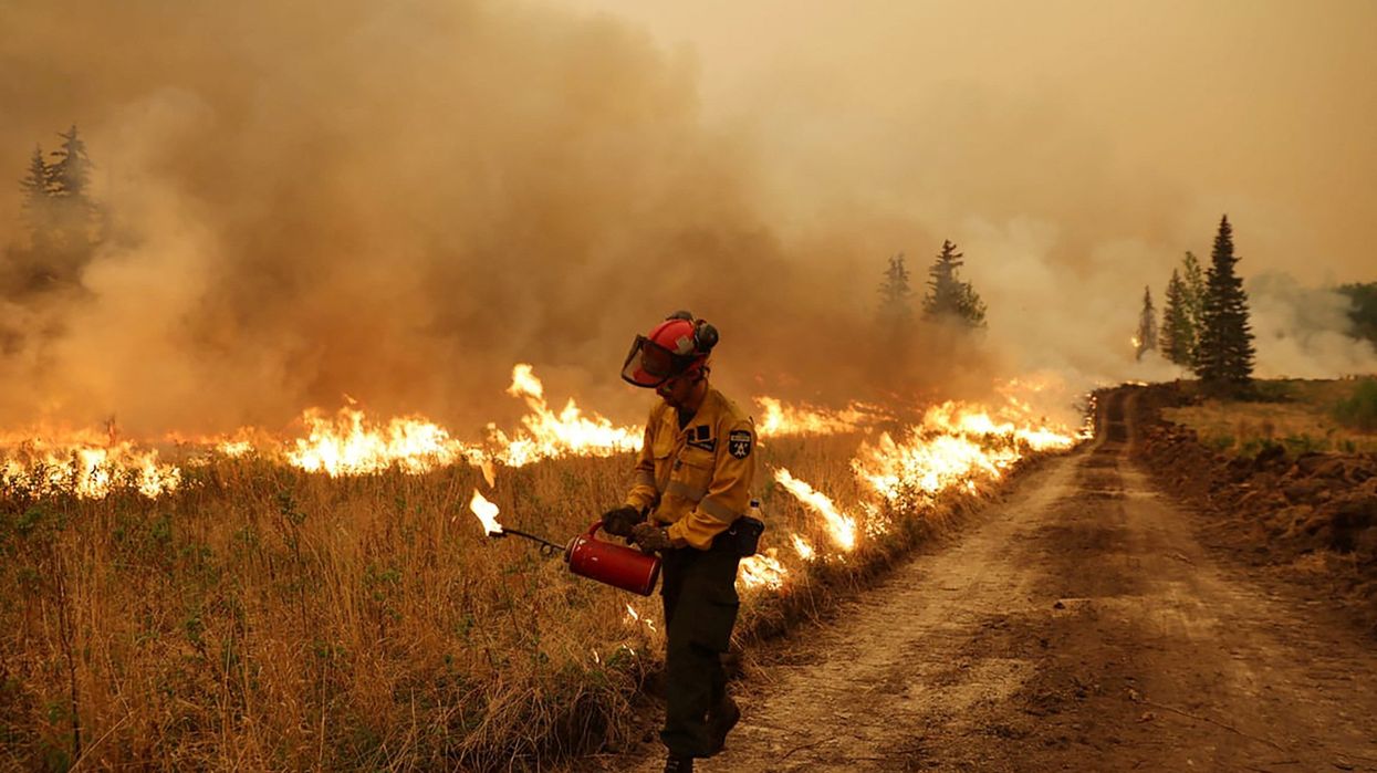A firefighter conducts a controlled ignition on the Sturgeon Lake Wildfire Complex GCX001 near Valleyview, Alberta.