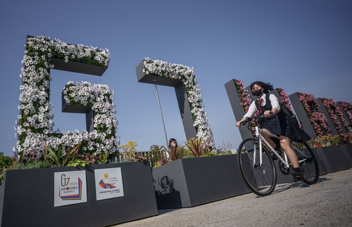 A G-7 sign, decorated with flowers, stands at the Hiroshima Peace Memorial in Japan.