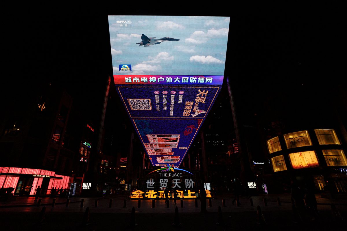 A giant screen in a Beijing mall broadcasts news footage of a Chinese fighter jet flying near Taiwan.