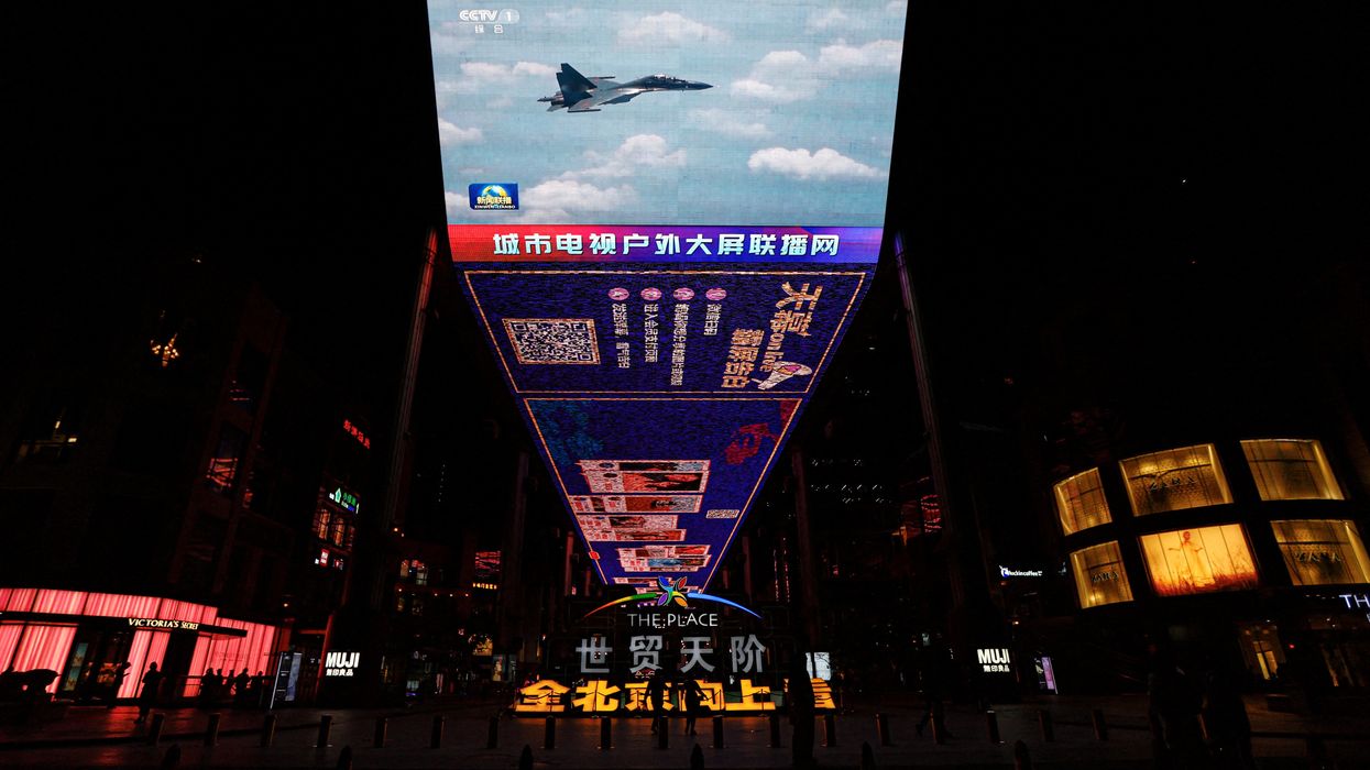 A giant screen in a Beijing mall broadcasts news footage of a Chinese fighter jet flying near Taiwan.