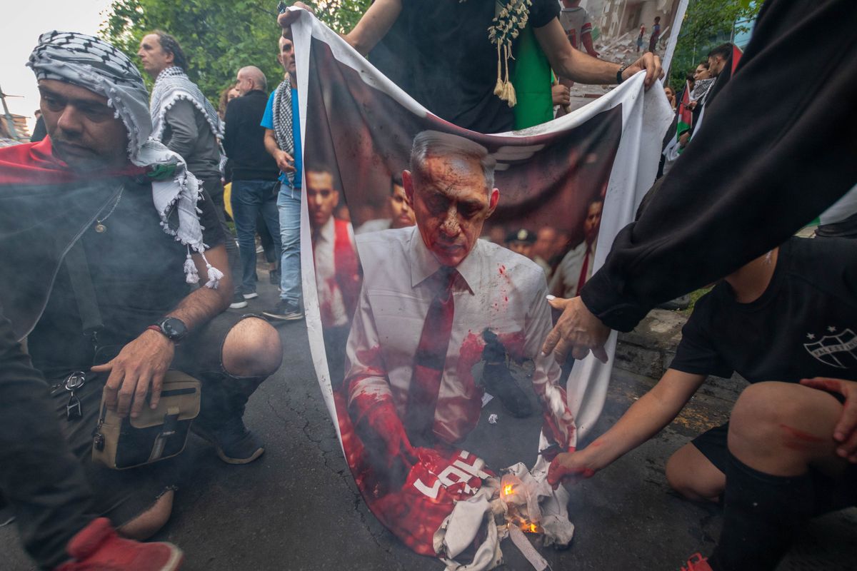 A group of demonstrators burns an image of the Prime Minister of Israel, BENJAMÍN NETANYAHU, during a protest in front of the Israel Embassy in Santiago, Chile, for his military actions in Gaza.
