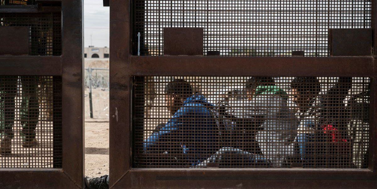 ​A group of migrants sit as they wait to be transported for processing on the day the U.S. 5th Circuit Court of Appeals hears oral arguments on Texas' motion to lift a block on its SB4 immigration law that would allow state officials to arrest migrants suspected of being in the country illegally, in El Paso, Texas, U.S. March 20, 2024 . 