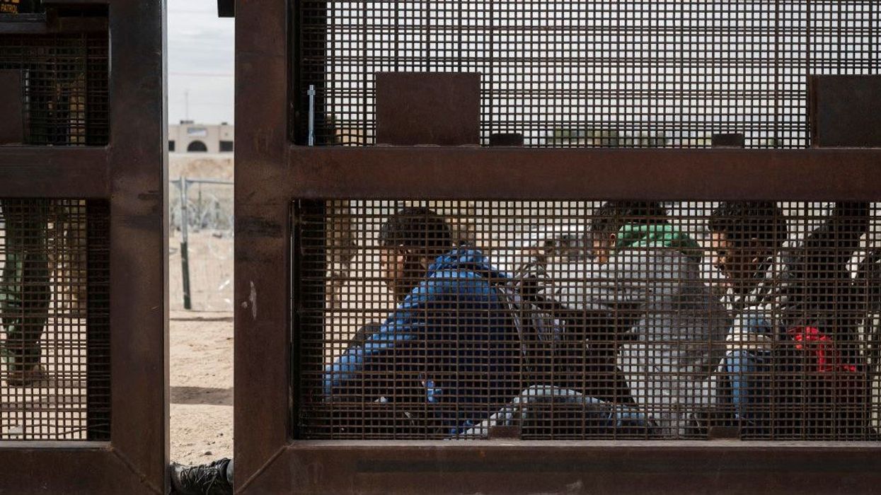 A group of migrants sit as they wait to be transported for processing on the day the U.S. 5th Circuit Court of Appeals hears oral arguments on Texas' motion to lift a block on its SB4 immigration law that would allow state officials to arrest migrants suspected of being in the country illegally, in El Paso, Texas, U.S. March 20, 2024 .