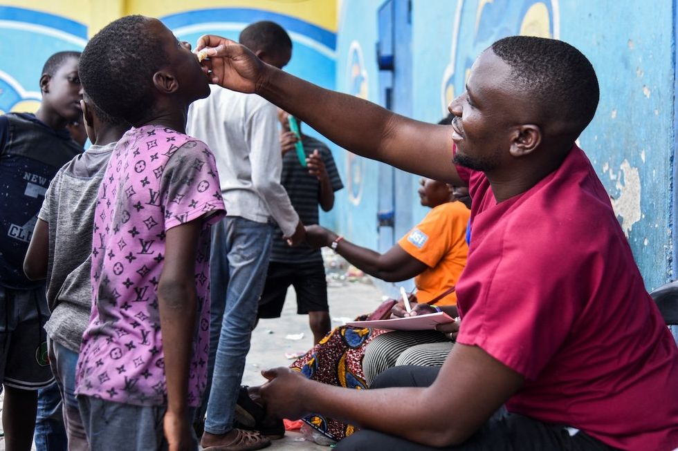 ​A man administers the cholera vaccine to a child at a temporary cholera treatment center set up to deal with the latest deadly cholera outbreak in Lusaka, Zambia.