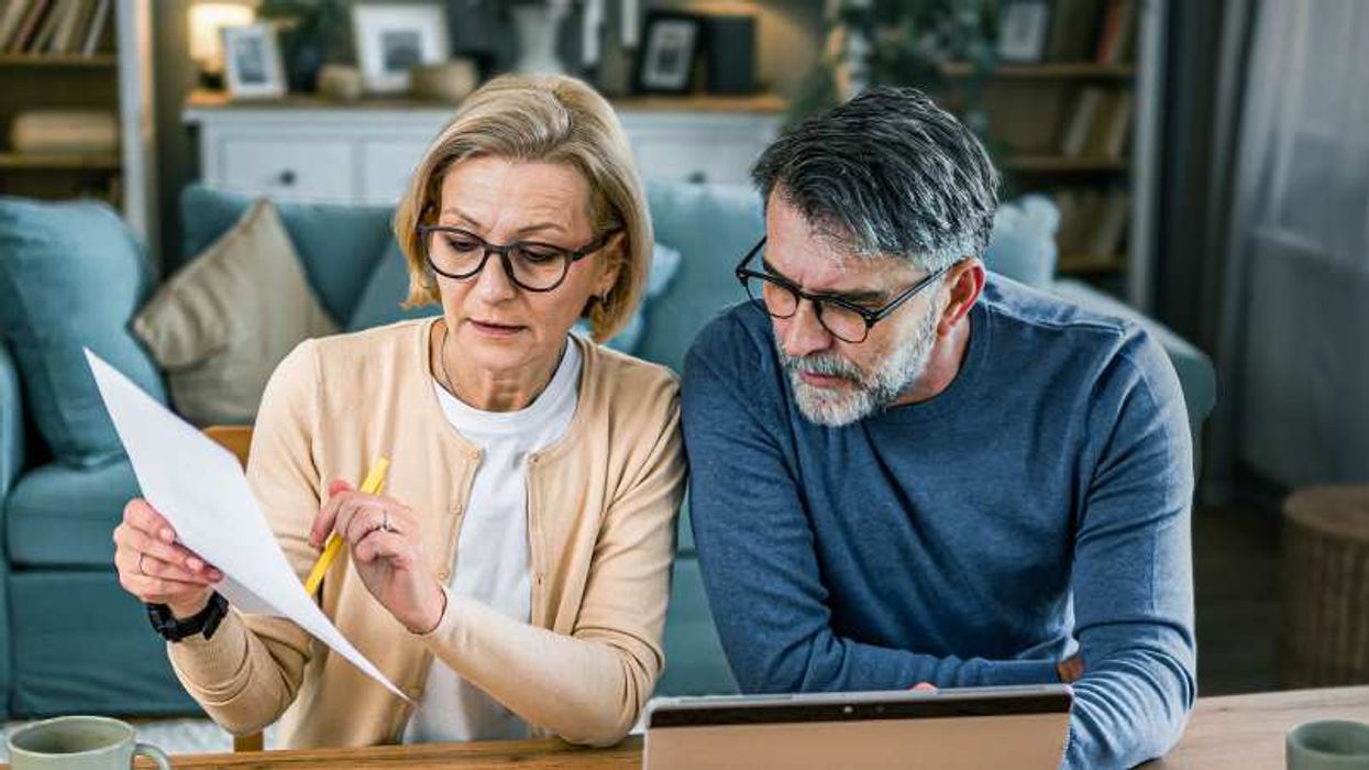 A man and a woman discussing with a paper in their hand