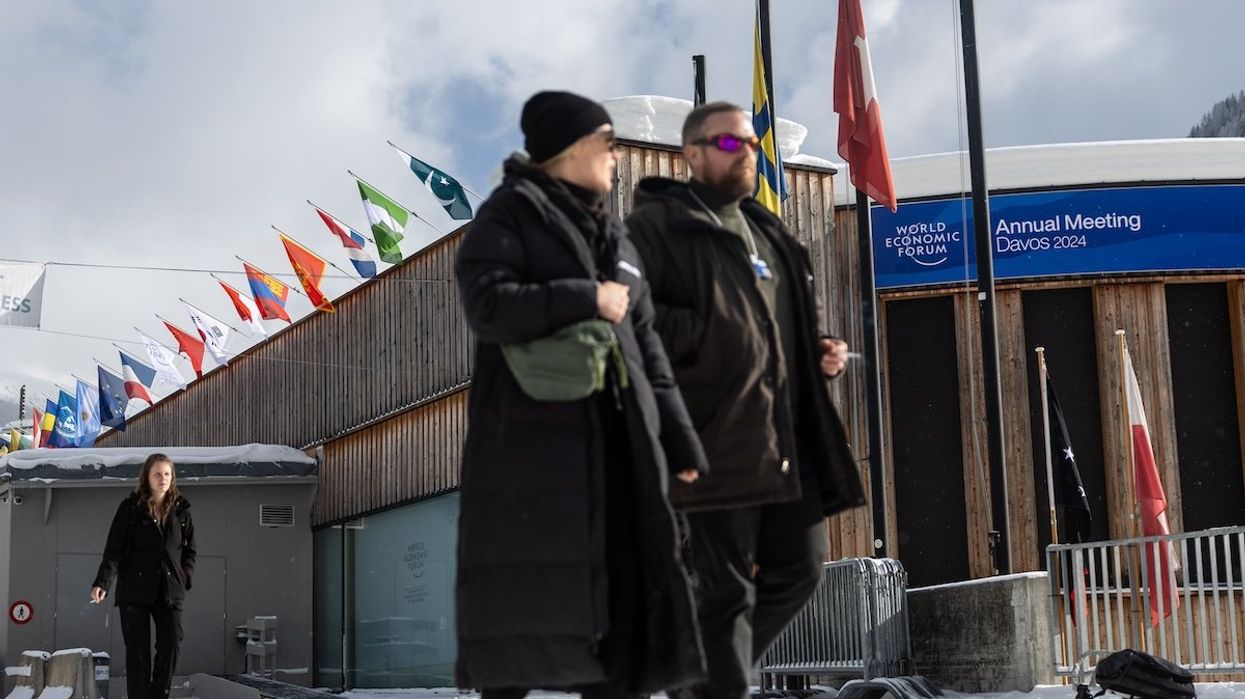 A man and woman walk in front of the World Economic Forum Convention Center in Davos, Switzerland.