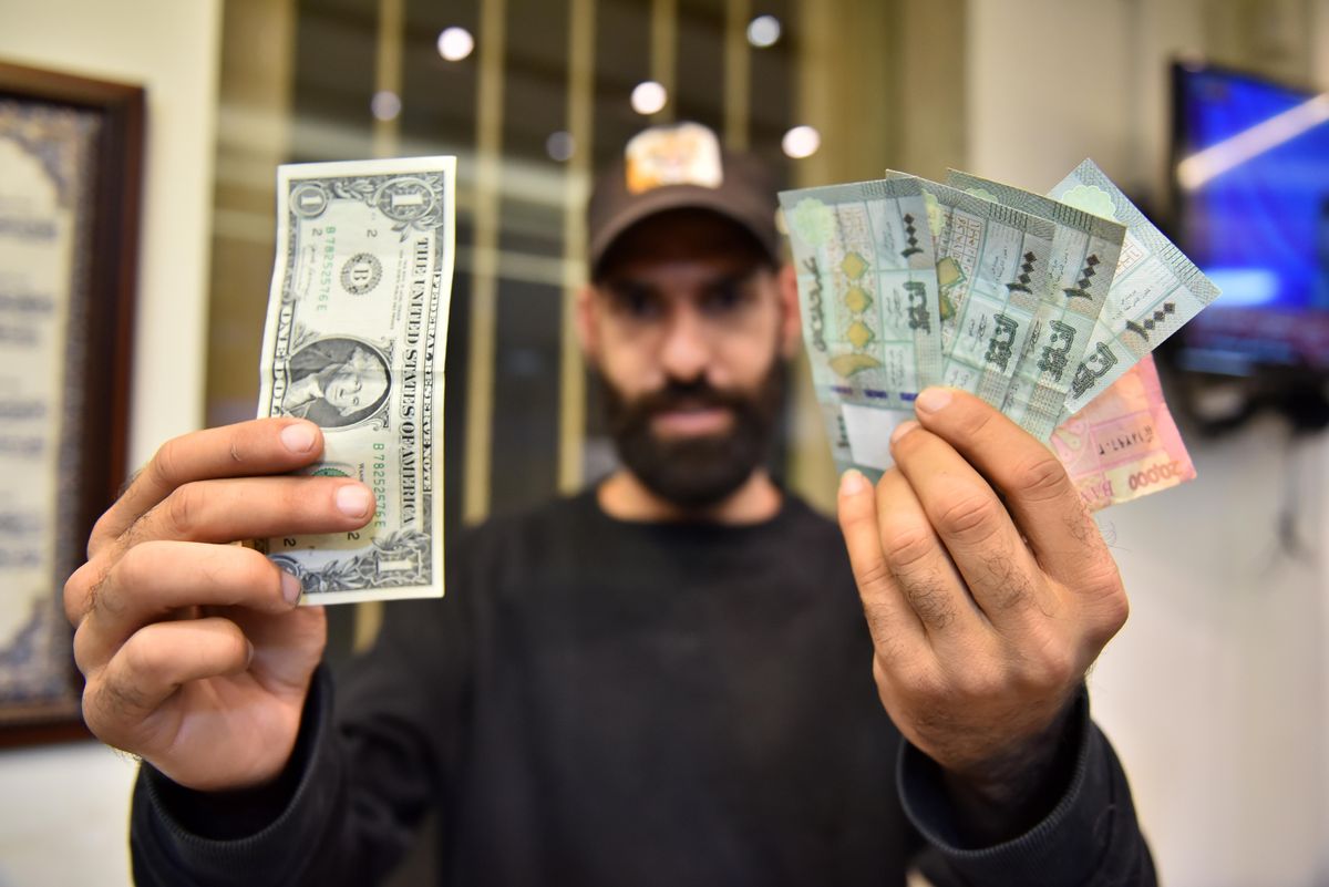 A man comparing US Dollars with Lebanese pounds, in Beirut, Lebanon. 
