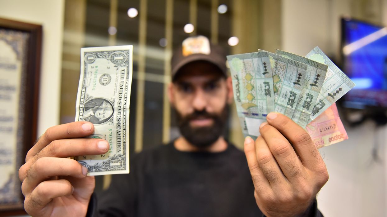 A man comparing US Dollars with Lebanese pounds, in Beirut, Lebanon.