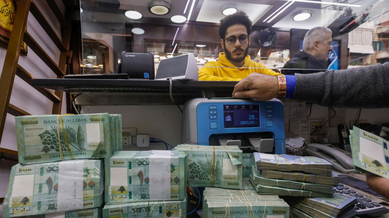 A man counts Lebanese pound banknotes at an exchange shop in Beirut, Lebanon.