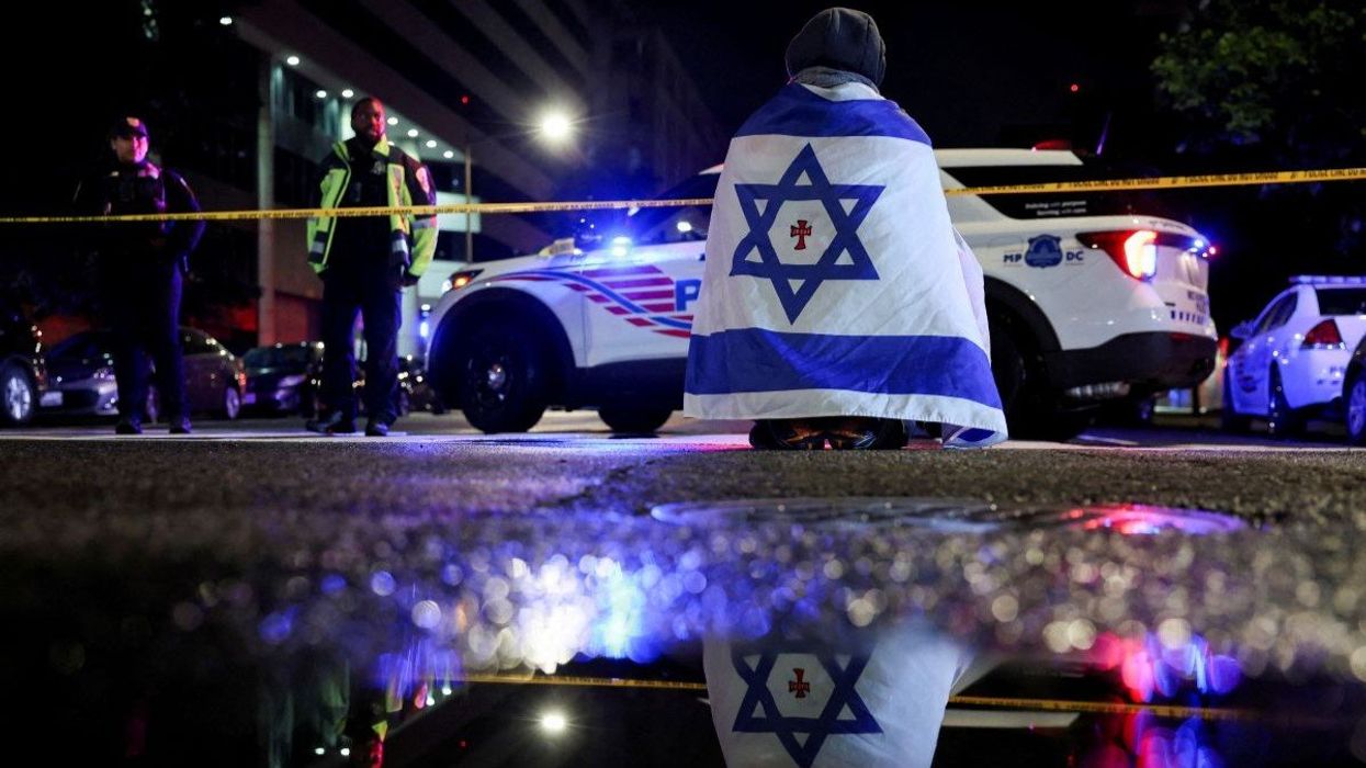 A man, draped in a version of the Israeli flag, stations himself outside the Capital Jewish Museum, in Washington, D.C., USA, on May 21, 2025.