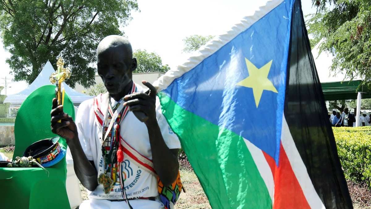 A man holding a South Sudan flag takes part in a national day of prayers for peace in Juba, South Sudan, on September 19, 2019.​