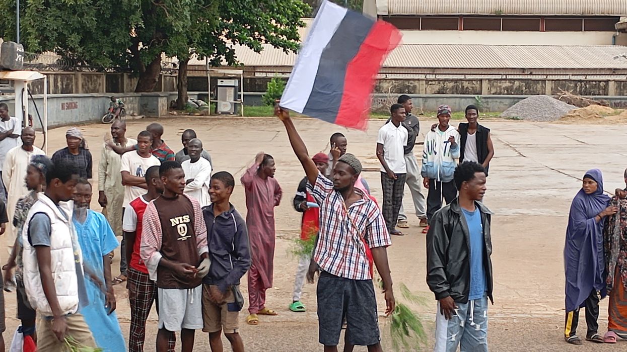 A man holds a Russian flag, as Nigerians protest in the streets during anti-government demonstrations against bad governance and economic hardship, in Kaduna state, Nigeria August 5, 2024.