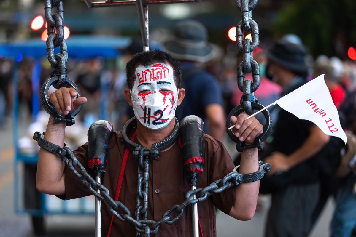 A man is seen with face paint reading "cancel lèse-majesté law" during a protest in Bangkok, Thailand.