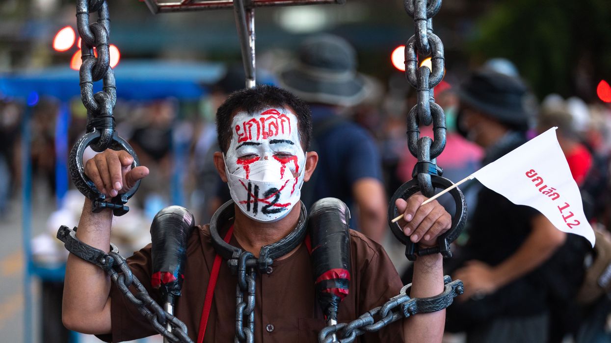A man is seen with face paint reading "cancel lèse-majesté law" during a protest in Bangkok, Thailand.