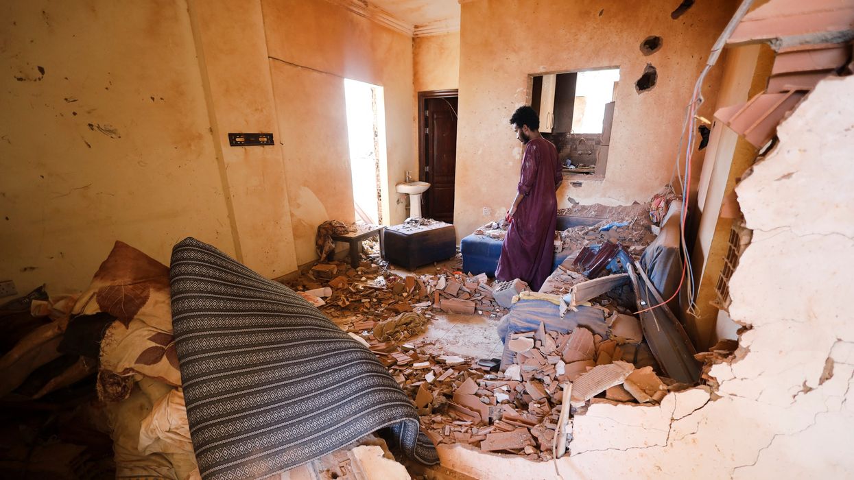 A man looks at belongings inside a damaged house during clashes between the RSF and the army in Khartoum.