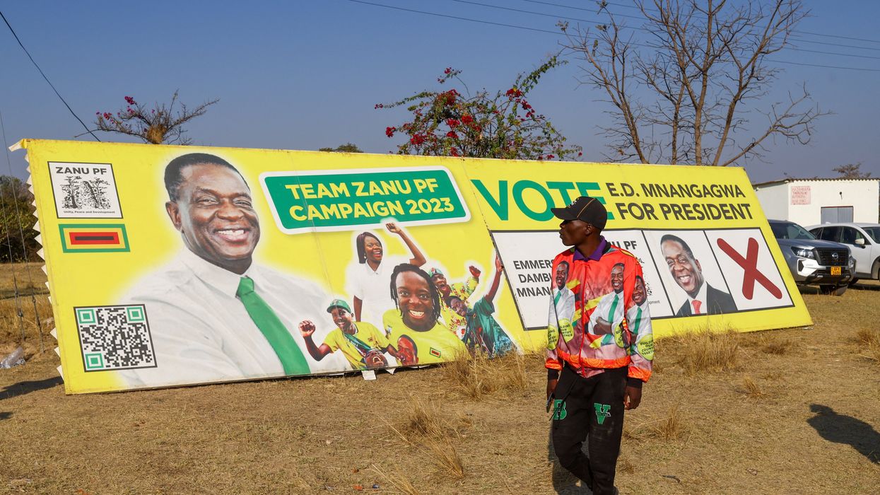 A man looks at the banner of Zimbabwe's President Emmerson Mnangagwa.