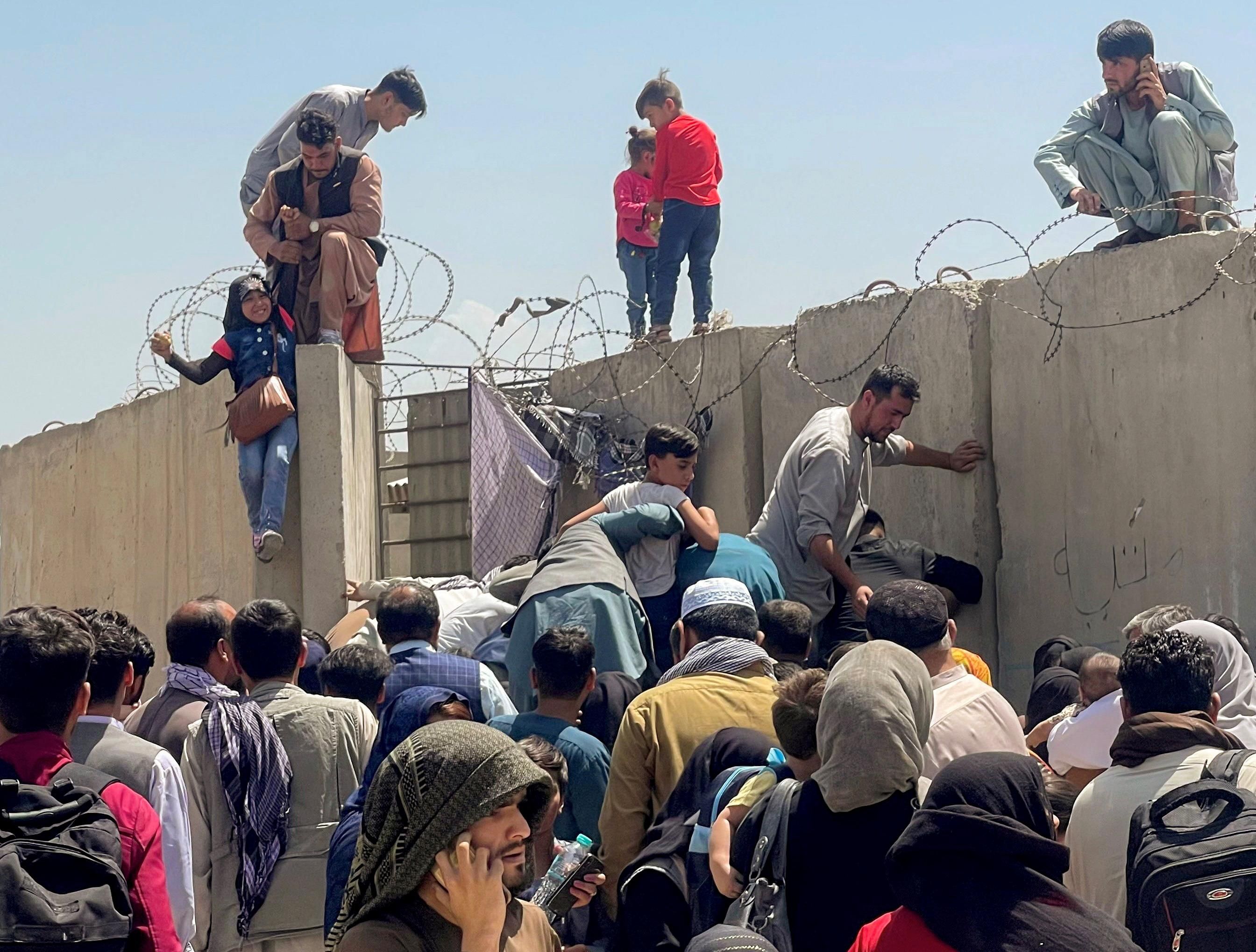 A man pulls a girl to get inside Hamid Karzai International Airport in Kabul, Afghanistan August 16, 2021.